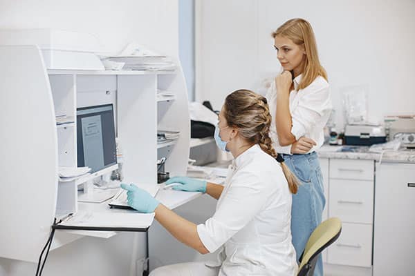 Two healthcare employees working on a computer to represent revenue cycle management services in Prescott Valley, Arizona